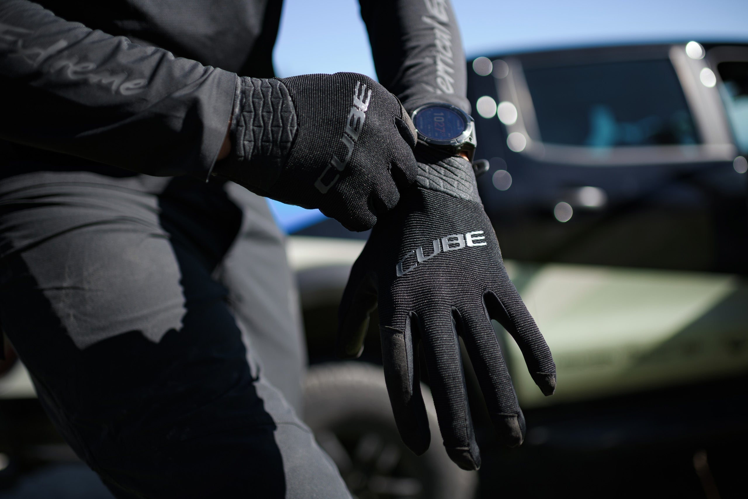 Close-up van handen die CUBE handschoenen aantrekken