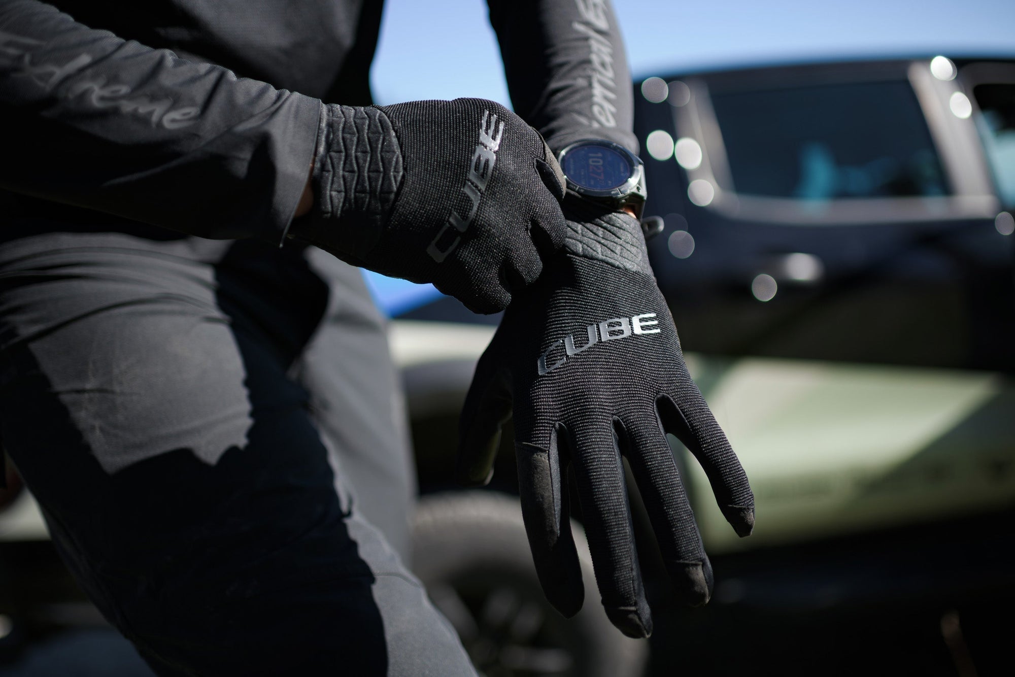 Close-up van handen die CUBE handschoenen aantrekken